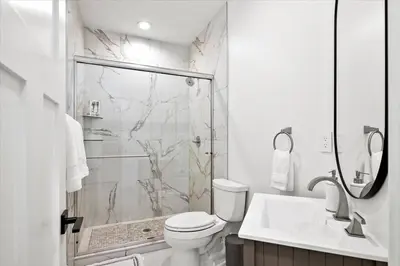 a bathroom with a shower and a toilet and a sink at New! Pure Luxury W Private Pool/Spa & Game Center! in Arvada