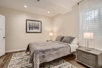 a bedroom with a bed and a table with two lamps at New! Pure Luxury W Private Pool/Spa & Game Center! in Arvada