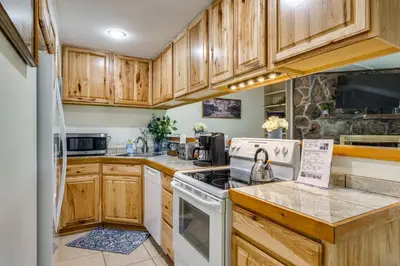 a kitchen with wooden cabinets and white appliances at 6 Mi to Keystone Resort Cozy Lake Dillon Condo! in Dillon