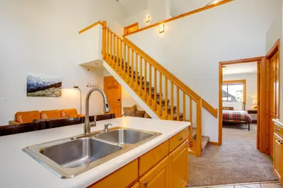 a kitchen with a sink and a staircase at Steps to Grand Lake New Deck at The Innlet Condo in Grand Lake