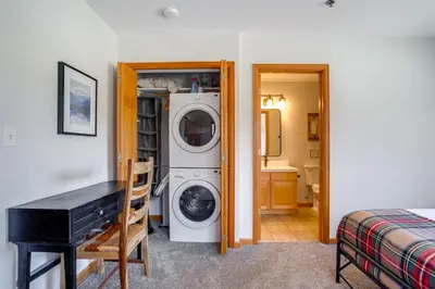 a room with a washer and dryer next to a bedroom at Steps to Grand Lake New Deck at The Innlet Condo in Grand Lake