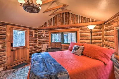 a bedroom with a bed in a log cabin at Forest-View Creekside Cabins with 4 Acres! in Evergreen