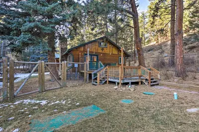 a log cabin in the woods with a playground at Forest-View Creekside Cabins with 4 Acres! in Evergreen