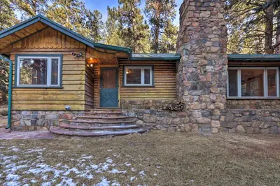 a log cabin with stairs leading to the front door at Forest-View Creekside Cabins with 4 Acres! in Evergreen
