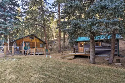 a log cabin in the woods with a playground at Forest-View Creekside Cabins with 4 Acres! in Evergreen