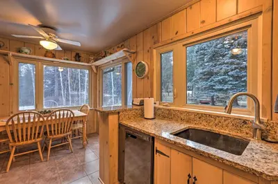 a kitchen with a sink and a table and chairs at Forest-View Creekside Cabins with 4 Acres! in Evergreen
