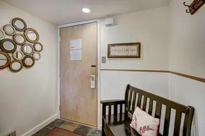 a hallway with a wooden door and a bench at Condo on Shuttle Rt-Wild Irishman with Pool and More in Keystone