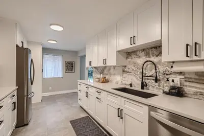 a kitchen with white cabinets and a sink at 6636 Depew St (upper) in Arvada