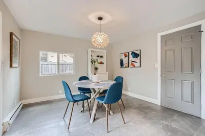 a dining room with a table and blue chairs at 6636 Depew St (upper) in Arvada