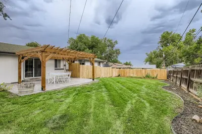 a backyard with a wooden pergola and a fence at 6636 Depew St (upper) in Arvada