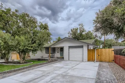 a white house with a fence and a driveway at 6636 Depew St (upper) in Arvada