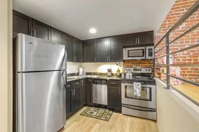 a kitchen with black cabinets and a stainless steel refrigerator at 2193 Arapahoe St Unit 17 in Denver