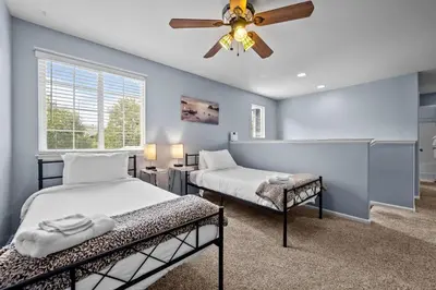 a bedroom with two beds and a ceiling fan at 1130 Mockingbird St in Brighton