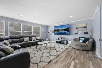 a living room with a black leather couch and chairs at 1130 Mockingbird St in Brighton