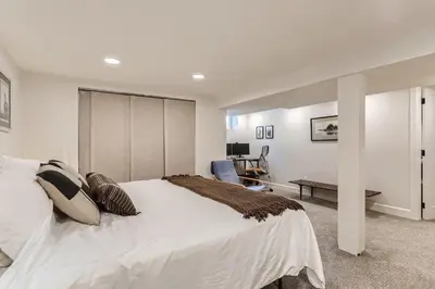 a bedroom with a large white bed and a desk at 2375 Ivanhoe St - Entire House in Denver