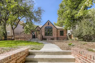 a brick house with a stone path leading to it at 2375 Ivanhoe St - Entire House in Denver