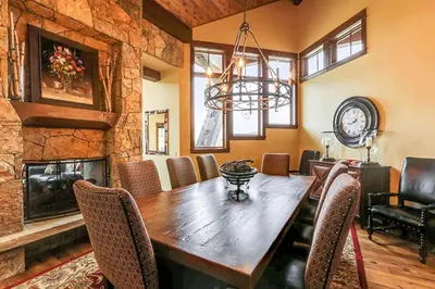 a dining room with a wooden table and a fireplace at Rocky Fells Lodge in Breckenridge