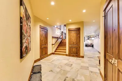 a hallway with wooden doors and a tile floor at Rocky Fells Lodge in Breckenridge