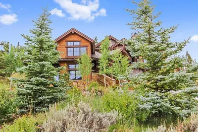 a large wooden house in the middle of trees at Rocky Fells Lodge in Breckenridge