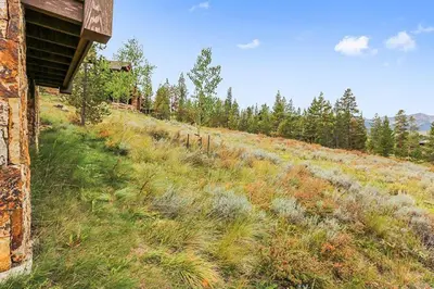 a field of grass with a building and trees at Rocky Fells Lodge in Breckenridge