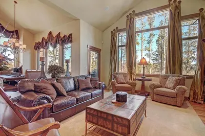 a living room with a couch and chairs and windows at Moose Crossing Lodge in Breckenridge