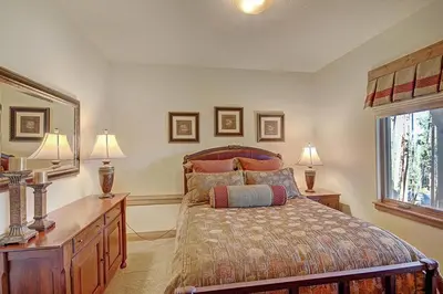 a bedroom with a bed and a desk with two lamps at Moose Crossing Lodge in Breckenridge
