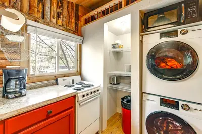 a kitchen with a stove and a washer and dryer at 1 Mi to Grand Lake Pet-Friendly Cabin with Grill! in Grand Lake