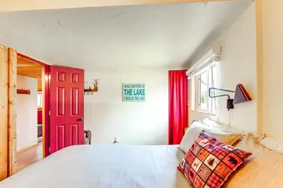 a bedroom with a red door and a bed at 1 Mi to Grand Lake Pet-Friendly Cabin with Grill! in Grand Lake