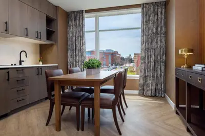 a kitchen with a table and chairs and a window at The Benson Hotel & Faculty Club in Aurora