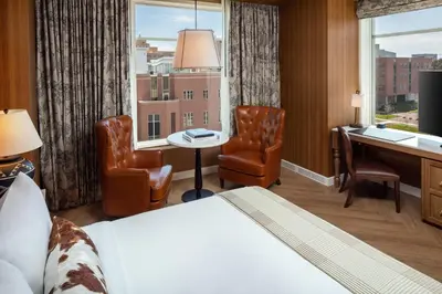 a hotel room with a bed and a desk and a window at The Benson Hotel & Faculty Club in Aurora