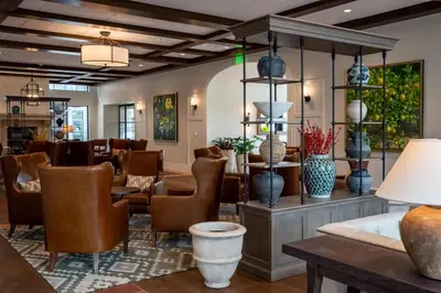 a lobby of a hotel with chairs and vases at The Benson Hotel & Faculty Club in Aurora