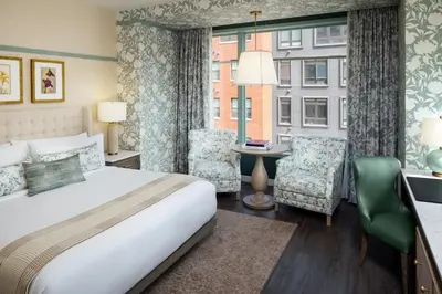 a bedroom with a bed and a desk and a window at The Benson Hotel & Faculty Club in Aurora