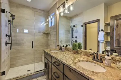 a bathroom with two sinks and a shower at half Mi to Dtwn Golden Gem with Patios! in Golden
