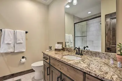 a bathroom with a sink and a toilet and a mirror at half Mi to Dtwn Golden Gem with Patios! in Golden