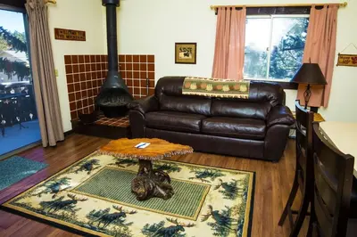 a living room with a leather couch and a fireplace at Elkhorn One Bedroom Condo with River View from Deck and Walking Distance to Estes Park - #3262 in Estes Park