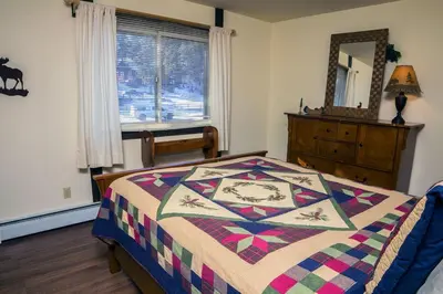 a bedroom with a bed with a quilt on it at Elkhorn One Bedroom Condo with River View from Deck and Walking Distance to Estes Park - #3262 in Estes Park