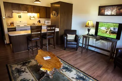 a living room with a kitchen with a table and a tv at Elkhorn One Bedroom Condo with River View from Deck and Walking Distance to Estes Park - #3262 in Estes Park