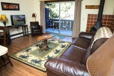 a living room with a leather couch and a table at Elkhorn One Bedroom Condo with River View from Deck and Walking Distance to Estes Park - #3262 in Estes Park