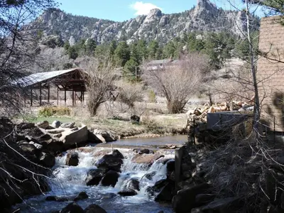 a river with rocks and a mountain in the background at Elkhorn One Bedroom Condo with River View from Deck and Walking Distance to Estes Park - #3262 in Estes Park