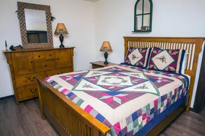 a bedroom with a bed and a dresser and a mirror at Elkhorn One Bedroom Condo with River View from Deck and Walking Distance to Estes Park - #3262 in Estes Park
