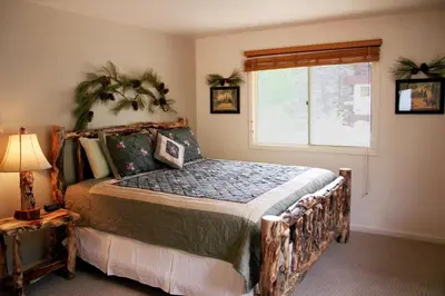 a bedroom with a large bed and a window at King Bed Condo with Personal Hot Tub on Deck with River View condo in Estes Park