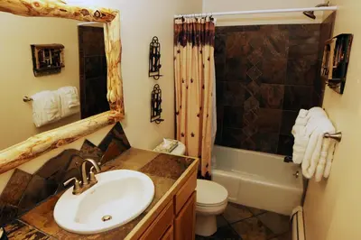 a bathroom with a sink and a toilet and a shower at King Bed Condo with Personal Hot Tub on Deck with River View condo in Estes Park