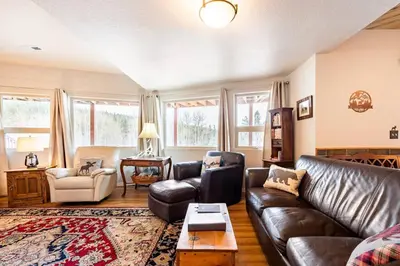 a living room with a leather couch and a table at Meandering Moose Apartment Vacation Rental in Black Hawk