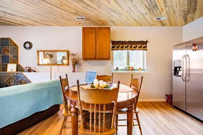a kitchen and dining room with a table and a refrigerator at Meandering Moose Apartment Vacation Rental in Black Hawk