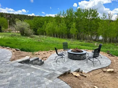 a fire pit in a yard with chairs and a fire place at Meandering Moose Apartment Vacation Rental in Black Hawk