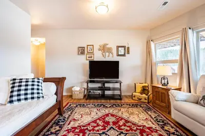 a living room with a couch and a flat screen tv at Meandering Moose Apartment Vacation Rental in Black Hawk