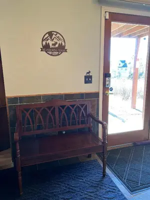 a wooden bench sitting in front of a door at Meandering Moose Apartment Vacation Rental in Black Hawk