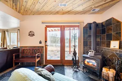 a living room with a fireplace and a stove at Meandering Moose Apartment Vacation Rental in Black Hawk