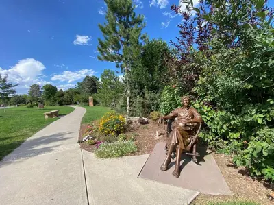 a statue of a man sitting on a bench in a park at Spacious, Cal King Bed, Sleeps 6, Full Kitchen in Loveland