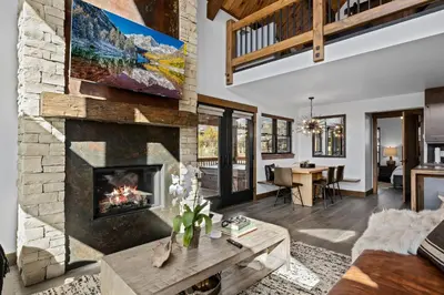 a living room with a fireplace and a table at Rocky Mountain Gem! Two Large patios, Fireplace and Private Jacuzzi in Estes Park